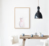 a colour pencil drawing of a pink galah on a white background in a teak frame hanging in a kitchen above a timber table