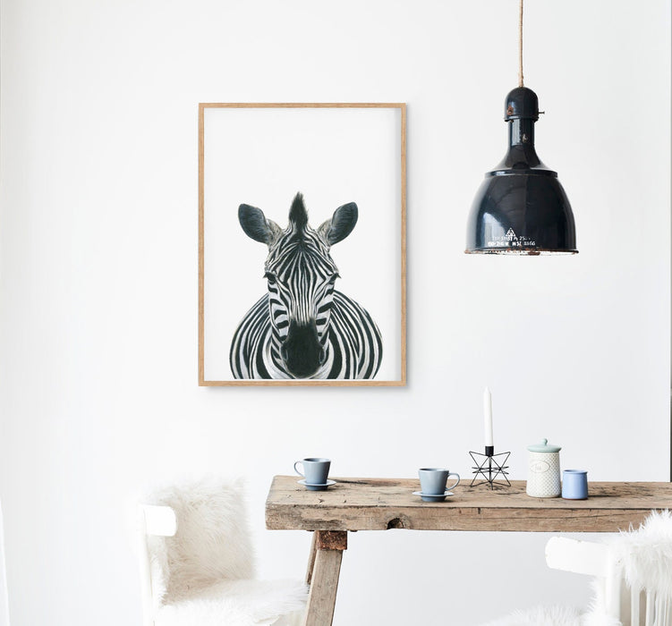 Drawing of a Zebra on a white background in a teak frame hanging in a kitchen above a table