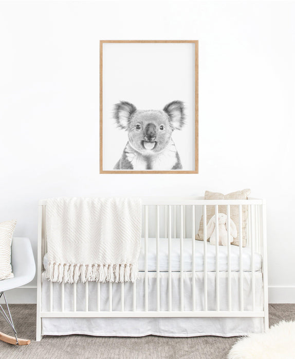 Black and White Koala Print in a timber frame hanging above a white cot in a nursery - the wild woods