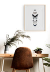 5 hand drawn butterflies in a timber frame hanging above a desk