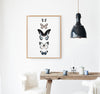 5 hand drawn butterflies in a timber frame hanging in a kitchen above a timber table