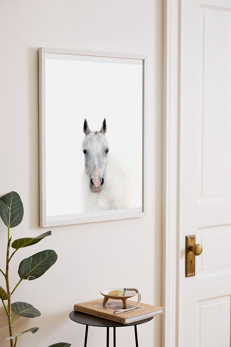 colour pencil drawing of a white horse portrait in a white frame hanging in a hallway next to a door