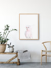 a colour pencil drawing of a pink galah on a white background in a teak frame above a timber bench