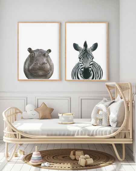 Hippopotamus and zebra prints in teak frames hanging in achildren's bedrrom