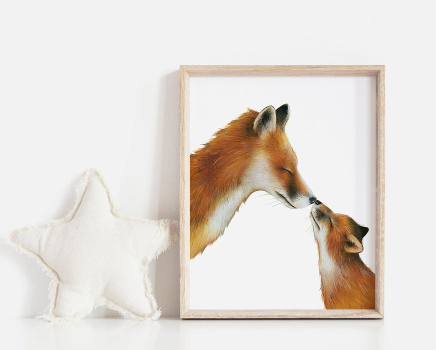 A drawing of a mama fox and her cub touching noses on a white background in a teak frame in a nursery