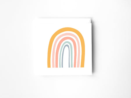 a drawing of a rainbow in colour pencil on a blank greeting card