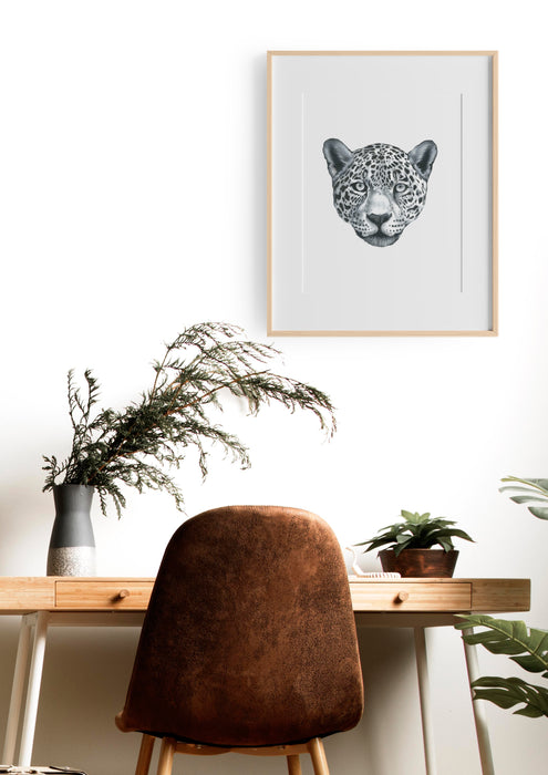 black and white portrait of a leopard in a teak frame hanging above a  desk
