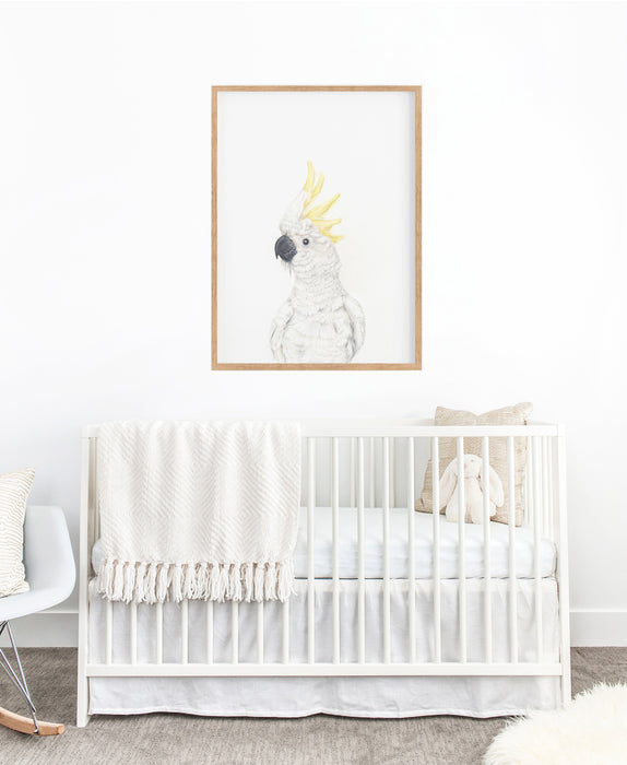 white cockatoo art print hanging above a white cot in a nursery