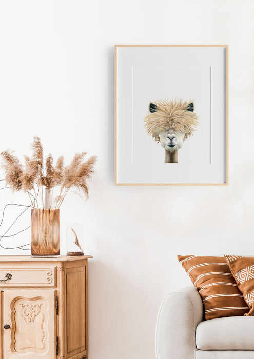 an illustration of a llama in a timber frame hanging above a white lounge in a living room