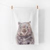 cotton tea towel printed with a wombat illustration, hanging on a line by pegs